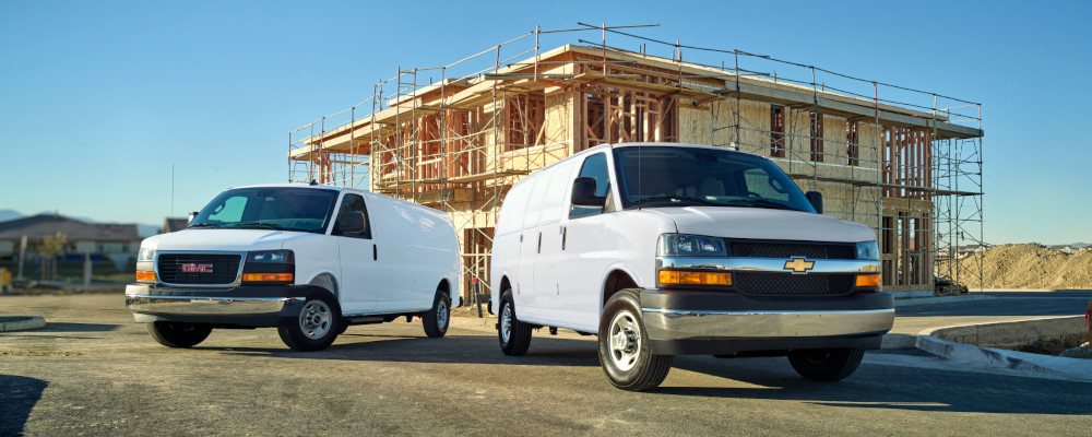 Two white work cargo vans on a construction site