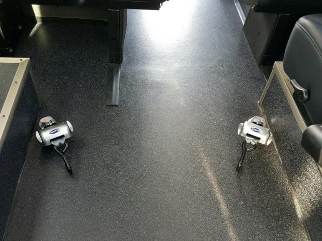 Interior floor of an LA West Luxury Coach with safety restraints for passengers.