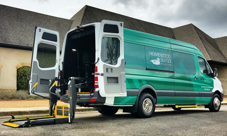 LA West Luxury Coach paratransit van with hotel branding and rear lift, for accessible transport needs in Birmingham, AL.