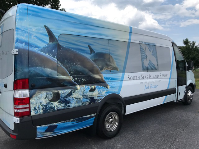 LA West Luxury Coach with resort advertising wrap, showing rear view of shuttle vehicle.