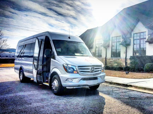 Silver LA West Luxury Coach shuttle van in front of a building, highlighting premium transport solutions from Mercedes-Benz of Birmingham.