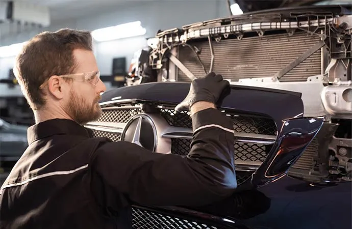 A Mercedes-Benz commercial service technician working on a Sprinter van in Shrewsbury, MA.