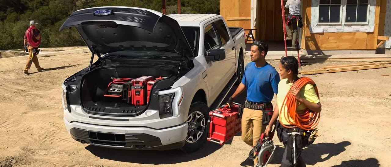 Construction workers loading equipment into a Ford F-150 Lightning Pro.