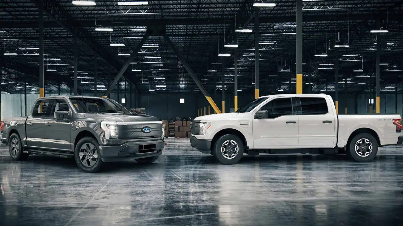 Dark grey and white Ford F-150 Lightning Pros parked inside a warehouse in Raleigh, NC.