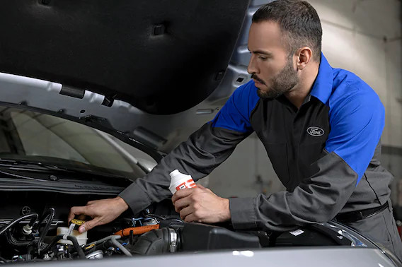 A service technician working on a Ford commercial vehicle at Randall Reed's Planet Ford Humble in TX.