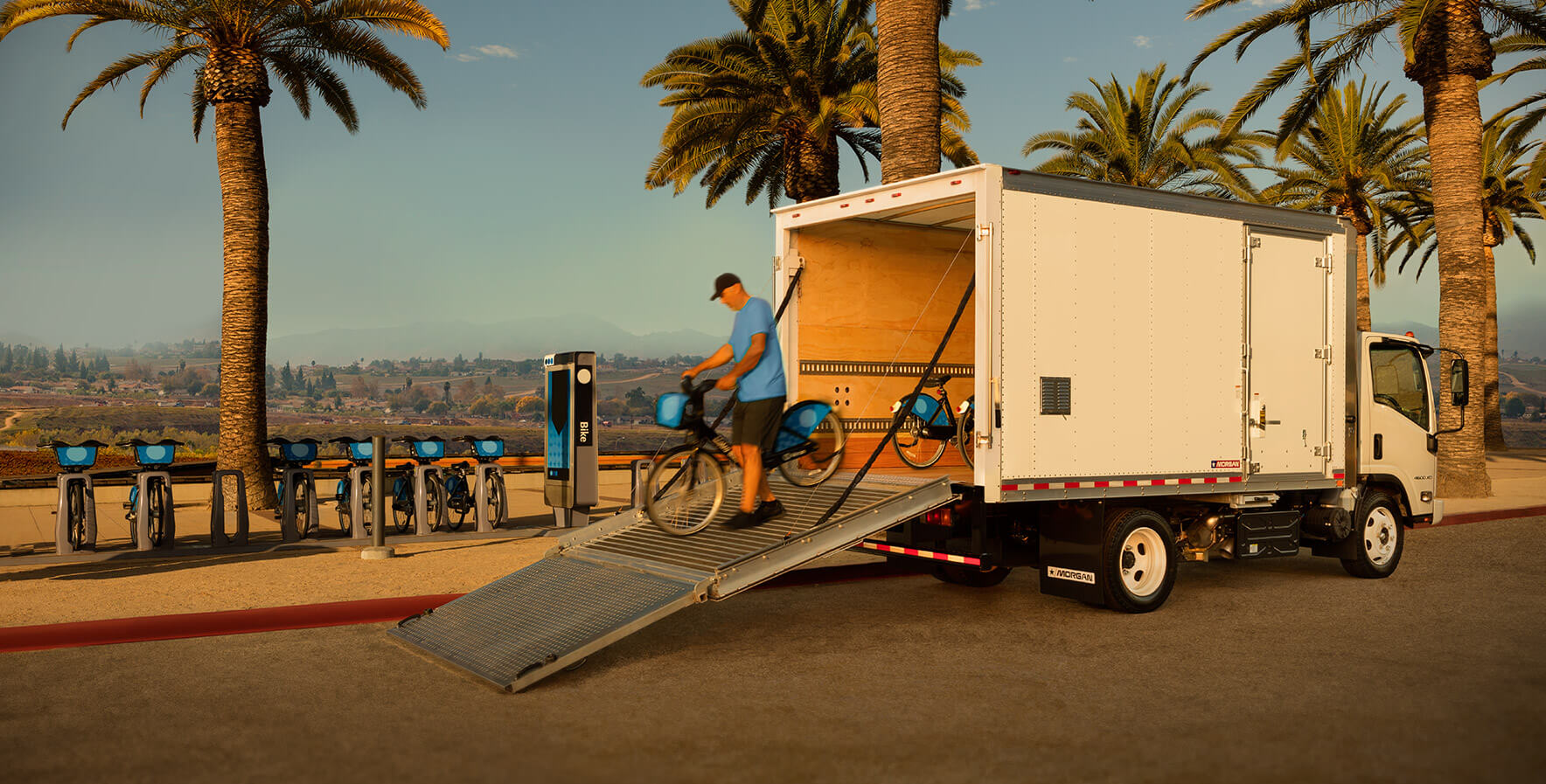 A person unloading e-bikes from a Morgan ProScape box truck.